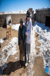 Tenzin Drolma (R) assists her grandmother into their house in Gyaga Village of Damxung County, southwest China`s Tibet Autonomous Region, Jan. 18, 2022.