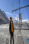 A scientific research member checks an Ozone flux unit at the Mount Qomolangma base camp on May 3, 2022. [Photo/Xinhua]