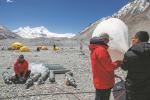 Scientific research members inflate a weather balloon at the Mount Qomolangma base camp on May 3, 2022. [Photo/Xinhua]