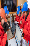 Staff members of the Meteorological Bureau of Tibet Autonomous Region exchange opinions on weather situation in a meteorological emergency support vehicle at the Mount Qomolangma base camp on May 3, 2022. [Photo/Xinhua]