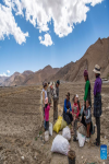 Villagers are seen in a field in Zhaxizom Township in Tingri County, southwest China`s Tibet Autonomous Region, May 10, 2022. At an altitude of about 4,200 meters, Zhaxizom is the nearest administrative township to Mount Qomolangma. Due to the high altitude and low temperature, spring farming here does not begin until May. (Xinhua/Sun Fei)