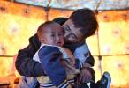 Shera Gyataso kisses his son inside a tent at a grazing point in Tsonyi County, southwest China`s Tibet Autonomous Region, July 18, 2022. (Xinhua/Jigme Dorje)