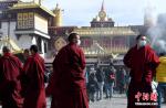 Monks from Yushu, northwest China`s Qinghai Province, gather for photos in front of the Jokhang Temple in Lhasa, southwest China`s Tibet Autonomous Region Jan. 12, 2023. (Photo: China News Service/Li Lin)