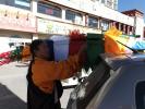 A Tibetan man ties some prayer flags he bought onto his car roof, ready to hang them on the roof of his house during the coming Losar New Year celebration. [Photo by Palden Nyima/chinadaily.com.cn]