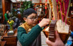 A boy in traditional costume eats chema, roasted barley and fried wheat grain in a two-tier rectangular wooden box, to celebrate the Tibetan New Year in Lhasa, southwest China`s Tibet Autonomous Region, Feb. 21, 2023.  (Xinhua/Jigme Dorje)