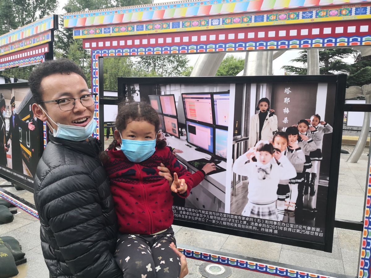 People visit a photo exhibition celebrating the 70th anniversary of Tibet`s peaceful liberation in Lhasa, Southwest China`s Tibet autonomous region, on Aug 25, 2021. [Photo provided to chinadaily.com.cn]