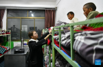 A teacher takes care of the pupils at the dormitory of a primary school of Zhaxizom Township in Tingri County, Xigaze City, southwest China`s Tibet Autonomous Region, June 5, 2023.