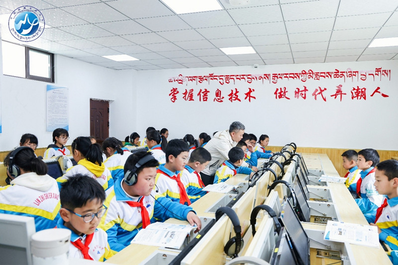 A teacher at Nyingchi No 2 Primary School explains concepts to students during a multimedia class. [Photo provided to China Daily]