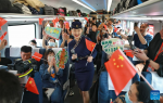 An attendant interacts with passengers on Fuxing bullet train C891 on the Xining-Golmud section of the Qinghai-Tibet Railway on July 1, 2023. [Photo/Xinhua]