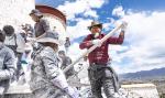 A worker stirs the paint during an annual renovation of the Potala Palace in Lhasa, southwest China`s Tibet Autonomous Region, Oct. 18, 2023. (Photo by Tenzin Nyida/Xinhua)
