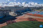This aerial photo taken on Nov. 10, 2023 shows students doing exercise at Damxung County Middle School in Damxung County, southwest China`s Xizang Autonomous Region. (Photo by Tenzin Nyida/Xinhua)