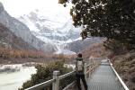 A tourist takes photos of Xiannairi, one of the snow-capped mountains at Daocheng Yading Nature Reserve in Ganzi, Sichuan. /CGTN