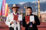 Attendees at the ceremony marking the opening of the Lijiang-Shangri-la railway show their commemorative train tickets in front of the Shangri-la railway station in Shangri-la, southwest China`s Yunnan Province, Nov. 26, 2023. (Xinhua/Chen Xinbo)