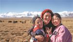 Sichod Drolma (right) and her sister embrace their father in a picturesque setting. TENZIN NYIDA/XINHUA