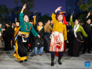 Dancers (front), who come from a Guozhuang dance troupe in Yushu Tibetan Autonomous Prefecture of Qinghai Province, dance with local dancers at a square in Chengdu, southwest China`s Sichuan Province, Dec. 23, 2023. (Xinhua/Shen Bohan)