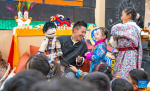 An actor interacts with children during a party at a bookstore in Lhasa, southwest China`s Xizang Autonomous Region, Feb. 3, 2024.  A unique party was held on Saturday at a bookstore for children in Lhasa City where teachers introduced the traditional customs of the Tibetan New Year. During the event, children wearing traditional Tibetan costumes enjoyed musical performance, puppet show and handicraft making, as well as a feast of `gutu`, a traditional soup dish made of flour. (Photo by Tenzin Nyida/Xinhua)