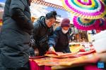 People shop for couplets at a local market for the upcoming Chinese New Year in Lhasa, southwest China`s Xizang Autonomous Region, Feb. 4, 2024. (Xinhua/Tenzin Nyida)