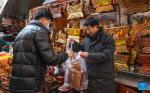A man shops for chema box at a local market for the upcoming Chinese New Year in Lhasa, southwest China`s Xizang Autonomous Region, Feb. 4, 2024. (Xinhua/Tenzin Nyida)