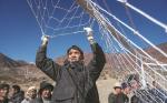 A villager fixes the net for a goal before a game on Jan 20. TENZIN NYIDA/XINHUA