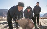 Villagers move a rock to level the makeshift pitch before a game on Jan 20. TENZIN NYIDA/XINHUA