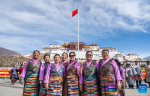 People pose for photos after a flag-raising ceremony to celebrate the Serfs` Emancipation Day at the square in front of the Potala Palace in Lhasa, capital of southwest China`s Xizang Autonomous Region, March 28, 2024. On March 28, 1959, people in Xizang launched the democratic reform, freeing a million serfs. In 2009, the regional legislature announced March 28 as the day to commemorate the emancipation of the one million serfs. (Xinhua/Tenzin Nyida)