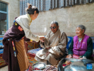 Padma`s granddaughter (L) serves a cup of butter tea to Padma and his wife at his residence in Shannan, southwest China`s Xizang Autonomous Region, March 27, 2024. Padma was born into a herdsman family in 1942 in Xainza County in Nagqu City, southwest China`s Xizang Autonomous Region. During his childhood, his family was obliged to herd over 1,000 sheep for aristocrats, only receiving meager sustenance in return.(Xinhua/Ding Ting)