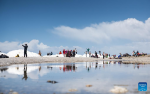 Tourists enjoy the scenery by the Lake Namtso in southwest China`s Xizang Autonomous Region, May 19, 2024. As temperature rises and ice melts, the Lake Namtso will enter its tourism season. (Xinhua/Tenzin Nyida)