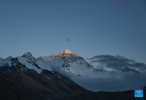 This photo taken on May 23, 2024 shows a view of the Mount Qomolangma at sunset in southwest China`s Xizang Autonomous Region. The Mount Qomolangma National Park has entered peak tourism season. From Jan. 1 to May 20 this year, the Mount Qomolangma scenic spot has received about 136,000 tourists. (Xinhua/Sun Fei)