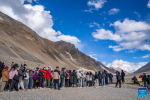 Tourists line up to take photos at the foot of Mount Qomolangma in southwest China`s Xizang Autonomous Region, May 24, 2024. The Mount Qomolangma National Park has entered peak tourism season. From Jan. 1 to May 20 this year, the Mount Qomolangma scenic spot has received about 136,000 tourists. (Xinhua/Sun Fei)