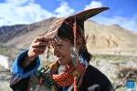 A villager displays folk costume in Kejia Village of Pulan County, southwest China`s Xizang Autonomous Region, Sept. 9, 2024.  Originating in Pulan County, Pulan folk costume has been a traditional garment worn at celebrations for over a millennium. Weighing more than 20 kilograms, a piece of this unique costume is usually decorated with rare metals and jewels, like gold, silver, beeswax, coral and turquoise. (Xinhua/Sun Ruibo)