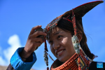 A villager displays folk costume in Kejia Village of Pulan County, southwest China`s Xizang Autonomous Region, Sept. 9, 2024.  Originating in Pulan County, Pulan folk costume has been a traditional garment worn at celebrations for over a millennium. Weighing more than 20 kilograms, a piece of this unique costume is usually decorated with rare metals and jewels, like gold, silver, beeswax, coral and turquoise. (Xinhua/Sun Ruibo)